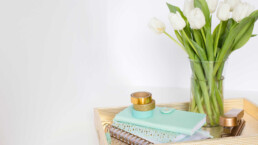 a desk with flowers and a turquoise notebook