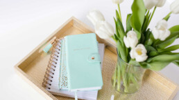 notebook and flowers on a desk