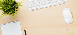 Office table with notepad, computer and coffee cup